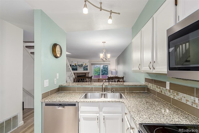 11147 W 17th Ave Unit 103, Lakewood, CO 80215 - kitchen with visible vents, appliances with stainless steel finishes, a sink, light wood-style floors, and white cabinetry