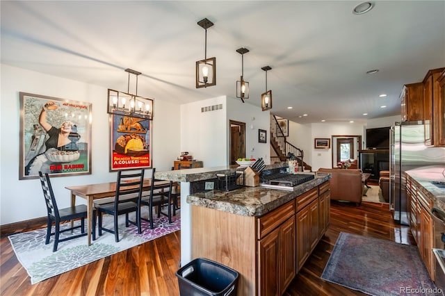 690 S Emerson St, Denver, CO 80209 - kitchen featuring dark wood-style flooring, stainless steel appliances, open floor plan, a kitchen island, and decorative light fixtures