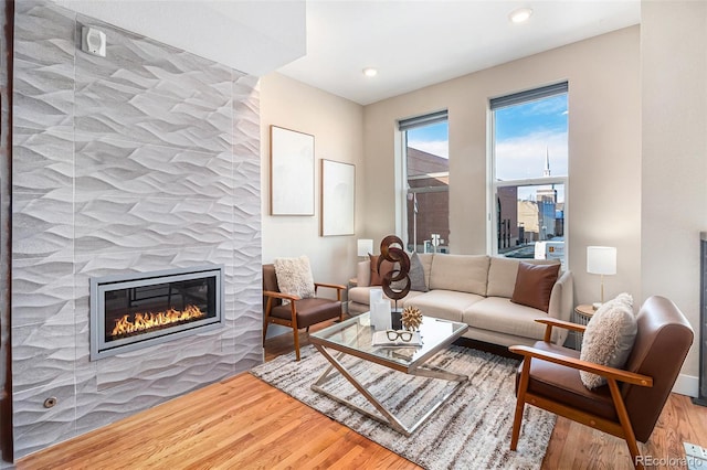 living room featuring light wood-type flooring and a tile fireplace