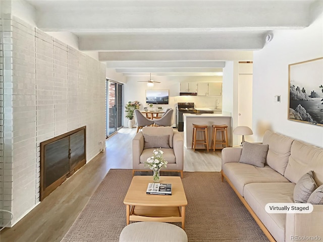 2401 S Gaylord St Unit 206, Denver, CO 80210 - living area featuring light wood-style flooring, beam ceiling, a glass covered fireplace, and ceiling fan