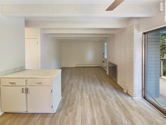 2401 S Gaylord St Unit 206, Denver, CO 80210 - hallway featuring light wood-style floors, beamed ceiling, brick wall, baseboard heating, and a textured ceiling