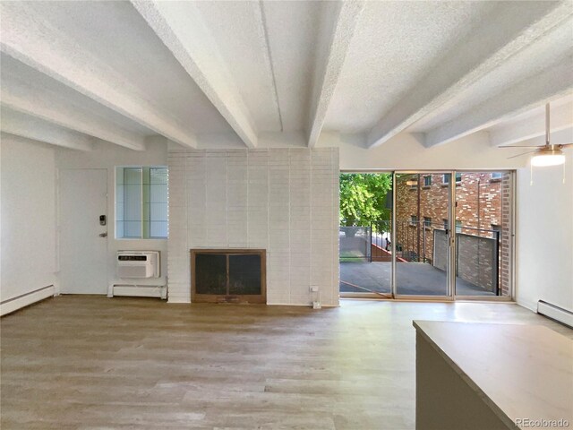 2401 S Gaylord St Unit 206, Denver, CO 80210 - unfurnished living room featuring a fireplace, beamed ceiling, a baseboard radiator, wood finished floors, and a textured ceiling
