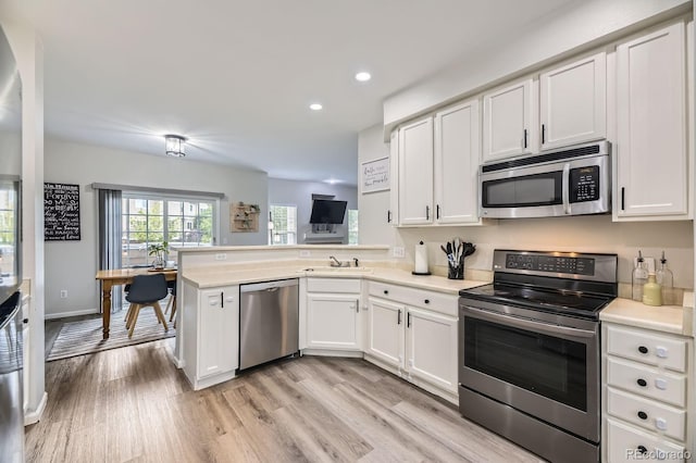 6819 S Webster St Unit B, Littleton, CO 80128 - kitchen with stainless steel appliances, white cabinets, recessed lighting, a peninsula, and light countertops