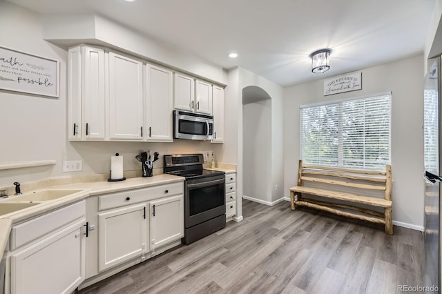 6819 S Webster St Unit B, Littleton, CO 80128 - kitchen featuring appliances with stainless steel finishes, light wood finished floors, light countertops, recessed lighting, and white cabinetry