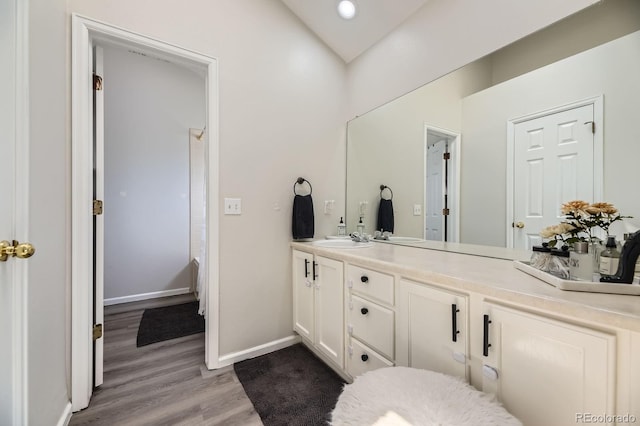 6819 S Webster St Unit B, Littleton, CO 80128 - bathroom featuring double vanity, wood finished floors, vaulted ceiling, and recessed lighting