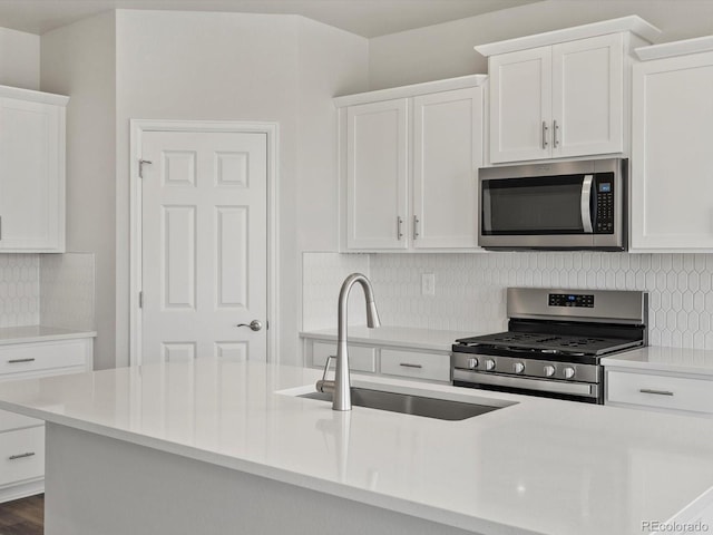 kitchen featuring appliances with stainless steel finishes, a sink, and white cabinetry