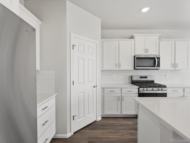 kitchen featuring stainless steel appliances, light countertops, white cabinets, dark wood-style floors, and recessed lighting