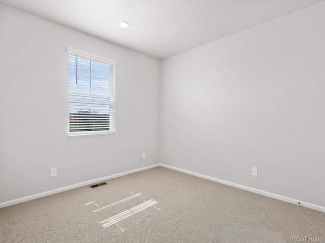 unfurnished room with carpet floors and baseboards