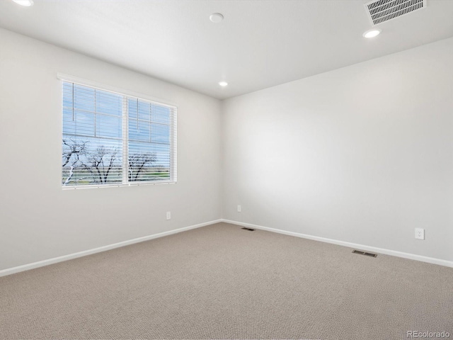 spare room featuring carpet flooring, baseboards, and recessed lighting