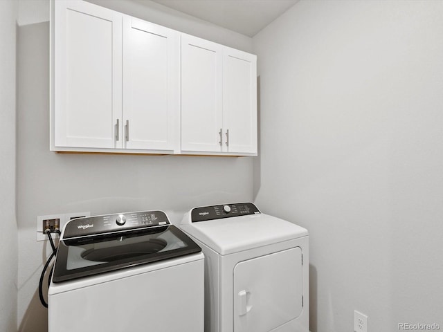 washroom featuring cabinet space and washer and clothes dryer