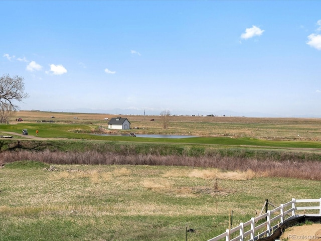 view of yard featuring a view of rural / pastoral area, fence, and a water view