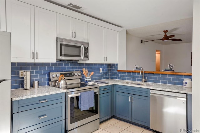 kitchen featuring stainless steel appliances, white cabinetry, sink, and blue cabinetry