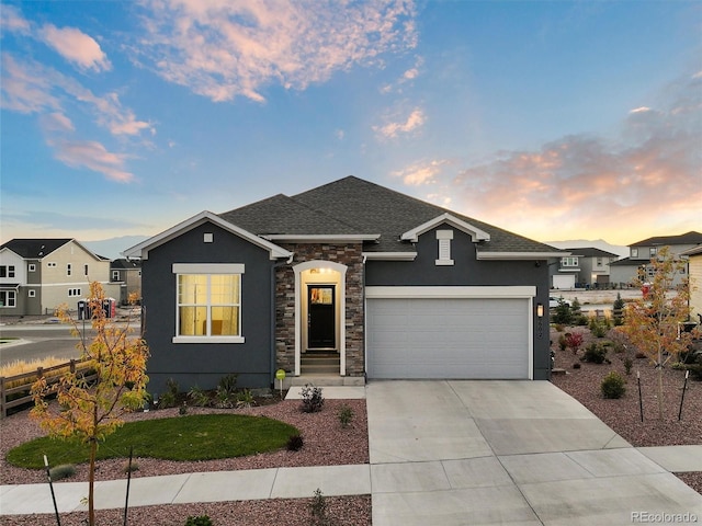 ranch-style home with a garage, driveway, stone siding, roof with shingles, and stucco siding