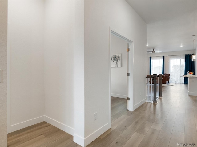 hall with recessed lighting, baseboards, and light wood finished floors