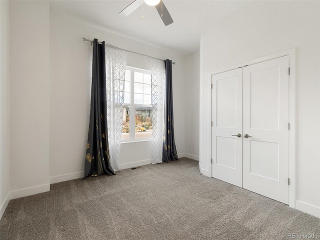 unfurnished bedroom featuring carpet flooring, visible vents, a ceiling fan, baseboards, and a closet