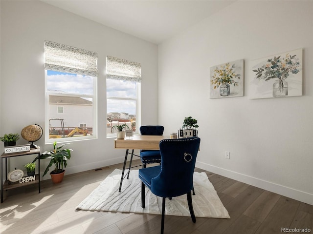 office area with baseboards, visible vents, and wood finished floors