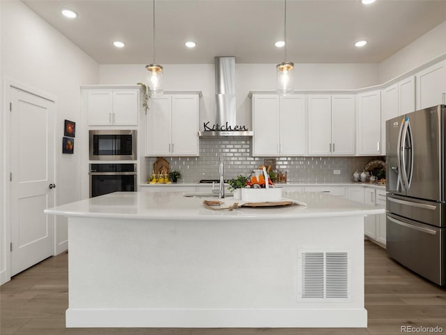 kitchen featuring light countertops, visible vents, appliances with stainless steel finishes, white cabinets, and wall chimney exhaust hood