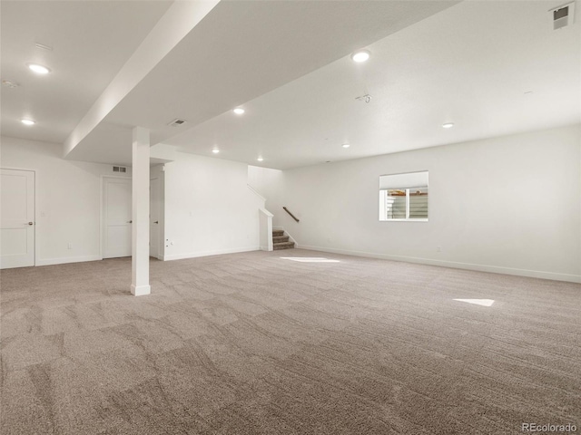 basement featuring light carpet, stairway, baseboards, and visible vents