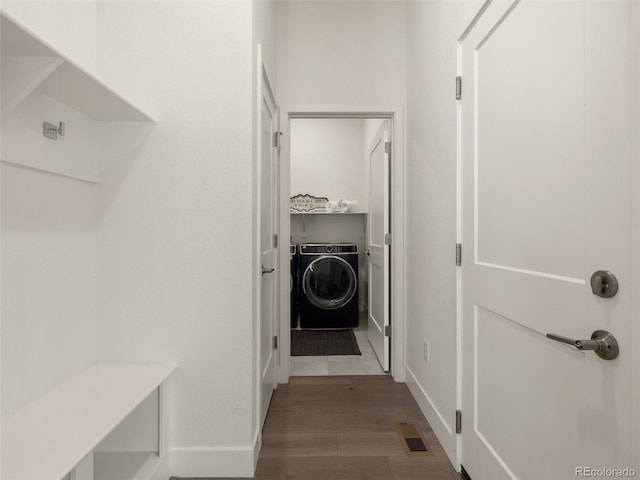 washroom with laundry area, wood finished floors, visible vents, baseboards, and washer / clothes dryer