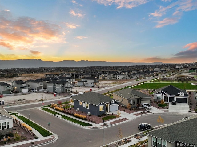 aerial view at dusk featuring a residential view and a mountain view