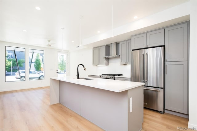 263 S Jackson St, Denver, CO 80209 - kitchen featuring high quality fridge, wall chimney exhaust hood, gray cabinets, a sink, and light wood-type flooring