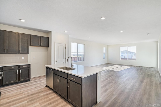 kitchen featuring plenty of natural light, dishwasher, light wood-type flooring, and sink