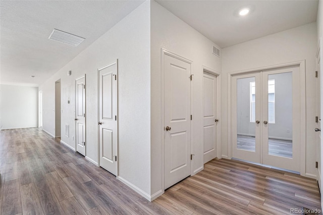 hall featuring dark hardwood / wood-style floors and french doors