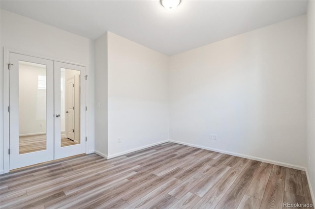 unfurnished room featuring french doors and light hardwood / wood-style floors