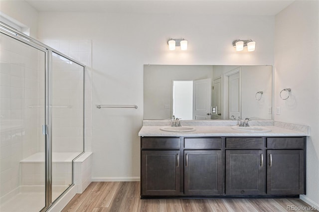 bathroom featuring vanity, hardwood / wood-style flooring, and a shower with shower door