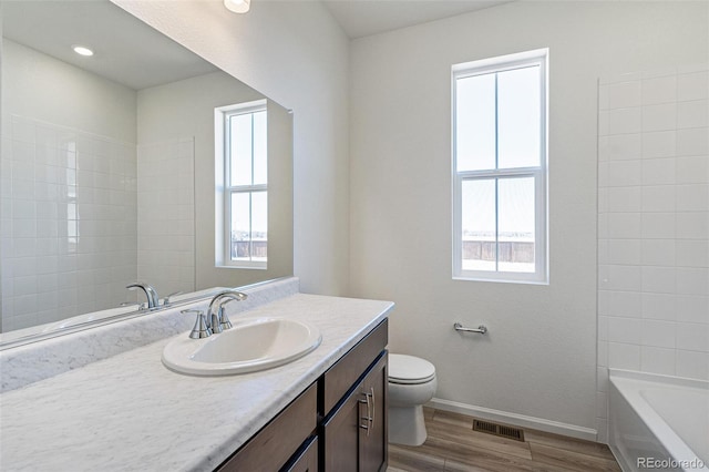 bathroom with toilet, vanity, and hardwood / wood-style flooring