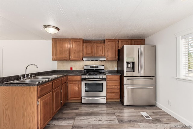 kitchen featuring a textured ceiling, stainless steel appliances, sink, and dark hardwood / wood-style flooring