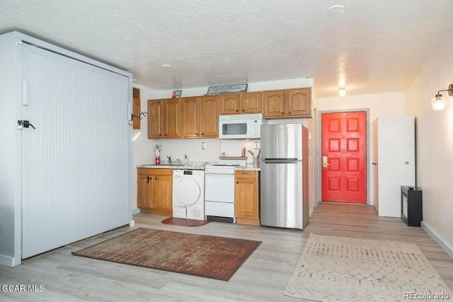 62927 US Highway 40 Unit 127, Granby, CO 80446 - kitchen with white appliances, light wood finished floors, light countertops, and brown cabinets
