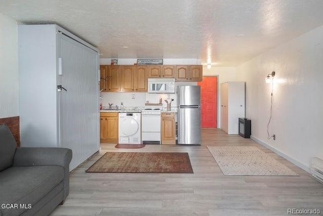 62927 US Highway 40 Unit 127, Granby, CO 80446 - kitchen with white appliances, open floor plan, light countertops, and light wood-style floors