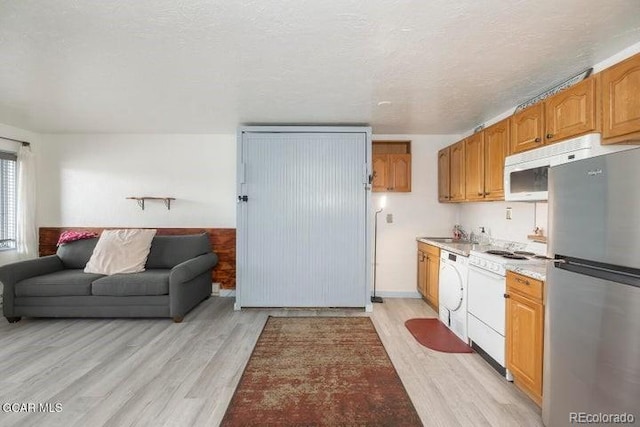 62927 US Highway 40 Unit 127, Granby, CO 80446 - kitchen with freestanding refrigerator, light wood-style flooring, light countertops, and white dishwasher