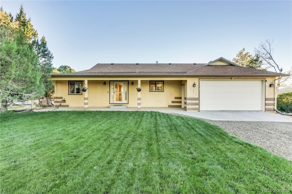 single story home with a garage, covered porch, and a front yard