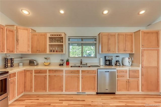 kitchen featuring light brown cabinetry, stainless steel appliances, light wood-type flooring, and sink