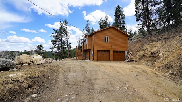 325 Bob Cat Trl, Bailey, CO 80421 - view of home's exterior with stairs, a garage, and dirt driveway