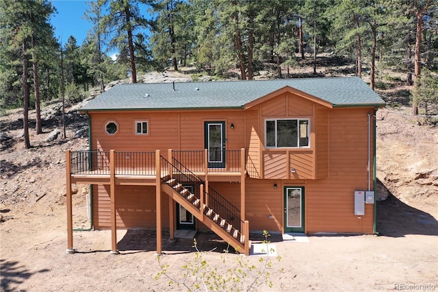 325 Bob Cat Trl, Bailey, CO 80421 - back of property featuring a deck, stairs, roof with shingles, and view of scattered trees