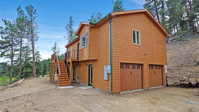 325 Bob Cat Trl, Bailey, CO 80421 - view of home's exterior featuring stairs, a garage, a deck, and driveway