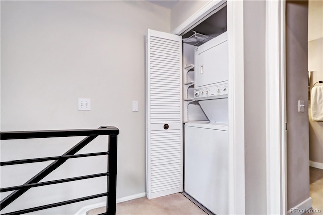 washroom with stacked washer and clothes dryer and light carpet