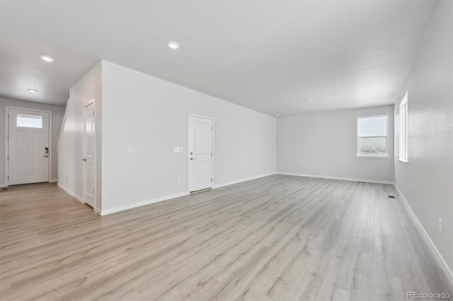 unfurnished room featuring light wood-style flooring, baseboards, and recessed lighting