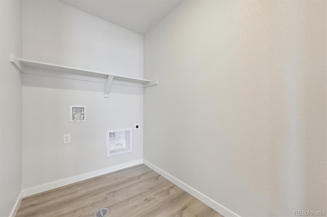 clothes washing area with electric dryer hookup, washer hookup, and light hardwood / wood-style floors