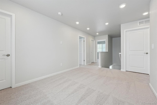 unfurnished room with recessed lighting, carpet flooring, visible vents, and baseboards