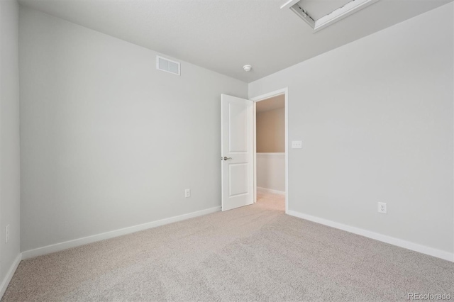 unfurnished room featuring carpet, visible vents, and baseboards