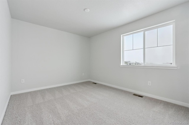 carpeted empty room with visible vents and baseboards