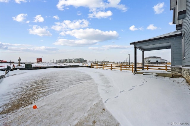 yard layered in snow with a carport and fence