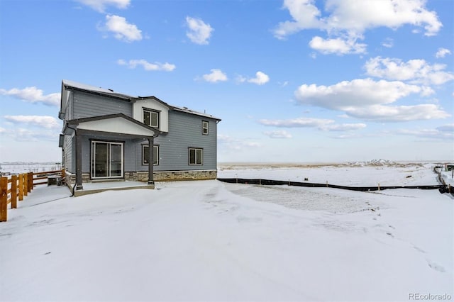 view of snow covered rear of property