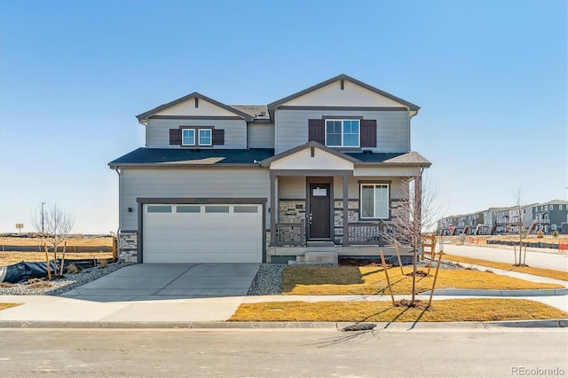 view of front of house with an attached garage, driveway, covered porch, and stone siding