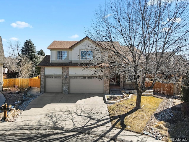 traditional-style home with a garage, concrete driveway, brick siding, and fence