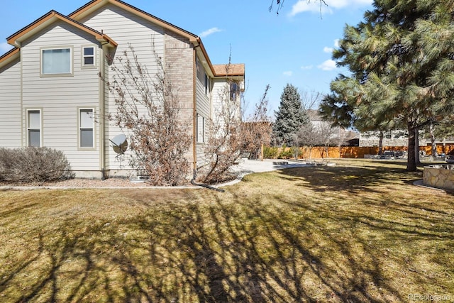 view of property exterior with a lawn and brick siding